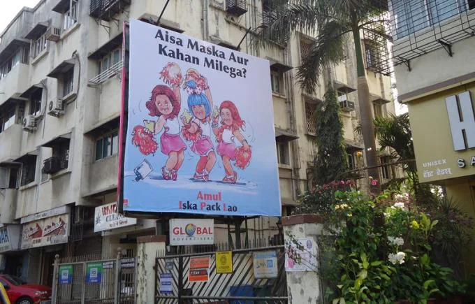 Amul billboard advertisement in an urban street showcasing a creative outdoor guerrilla marketing campaign in India with catchy visuals and brand messaging