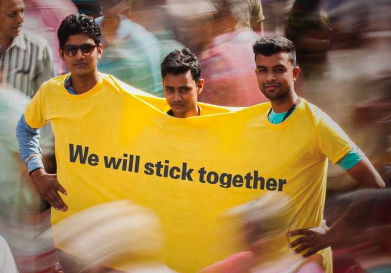 People wearing a connected yellow T-shirt with “We will stick together” message demonstrating a creative Fevicol guerrilla marketing campaign in India highlighting strong adhesive branding